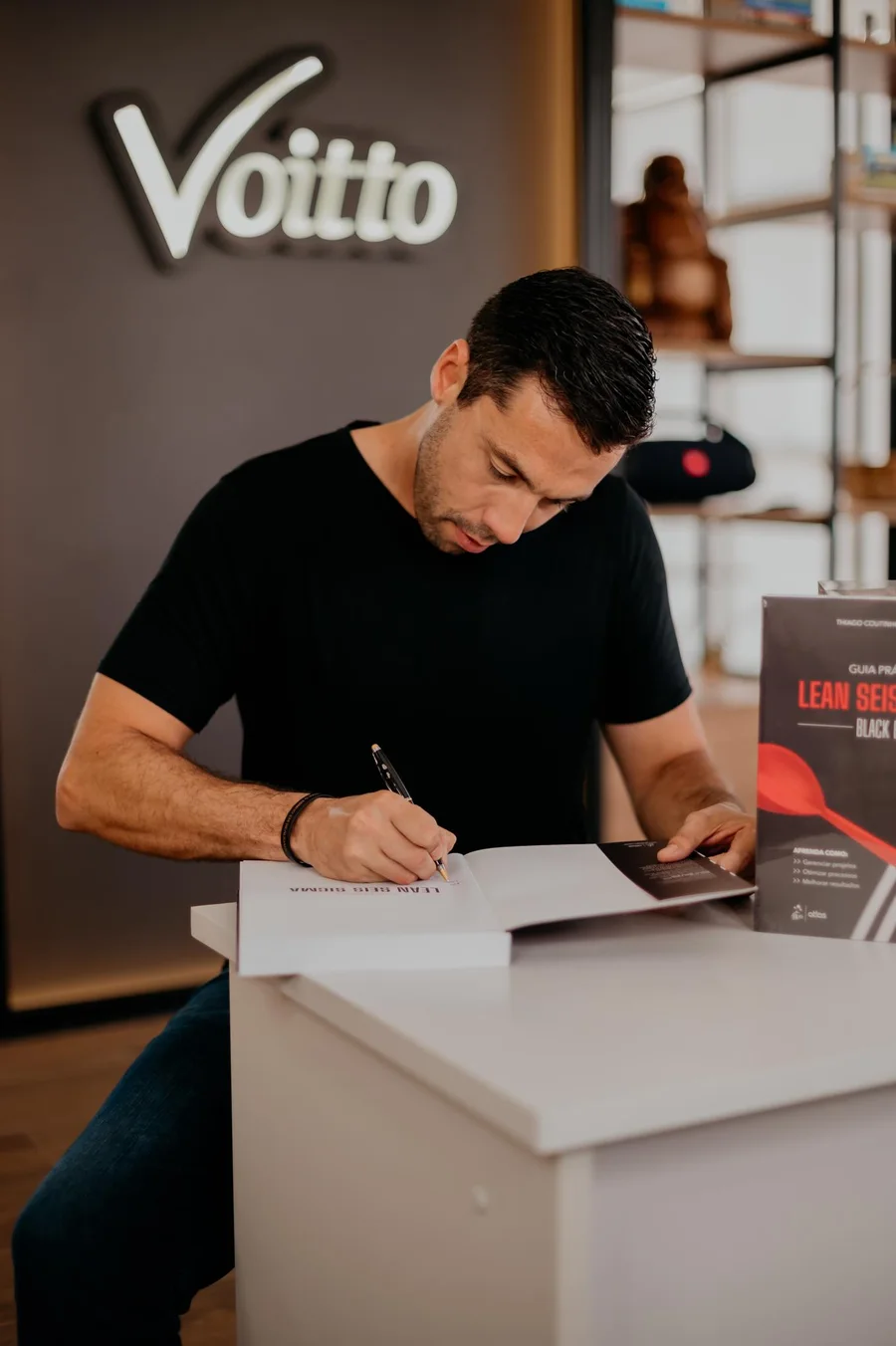 Thiago Coutinho assinando um documento sobre a mesa