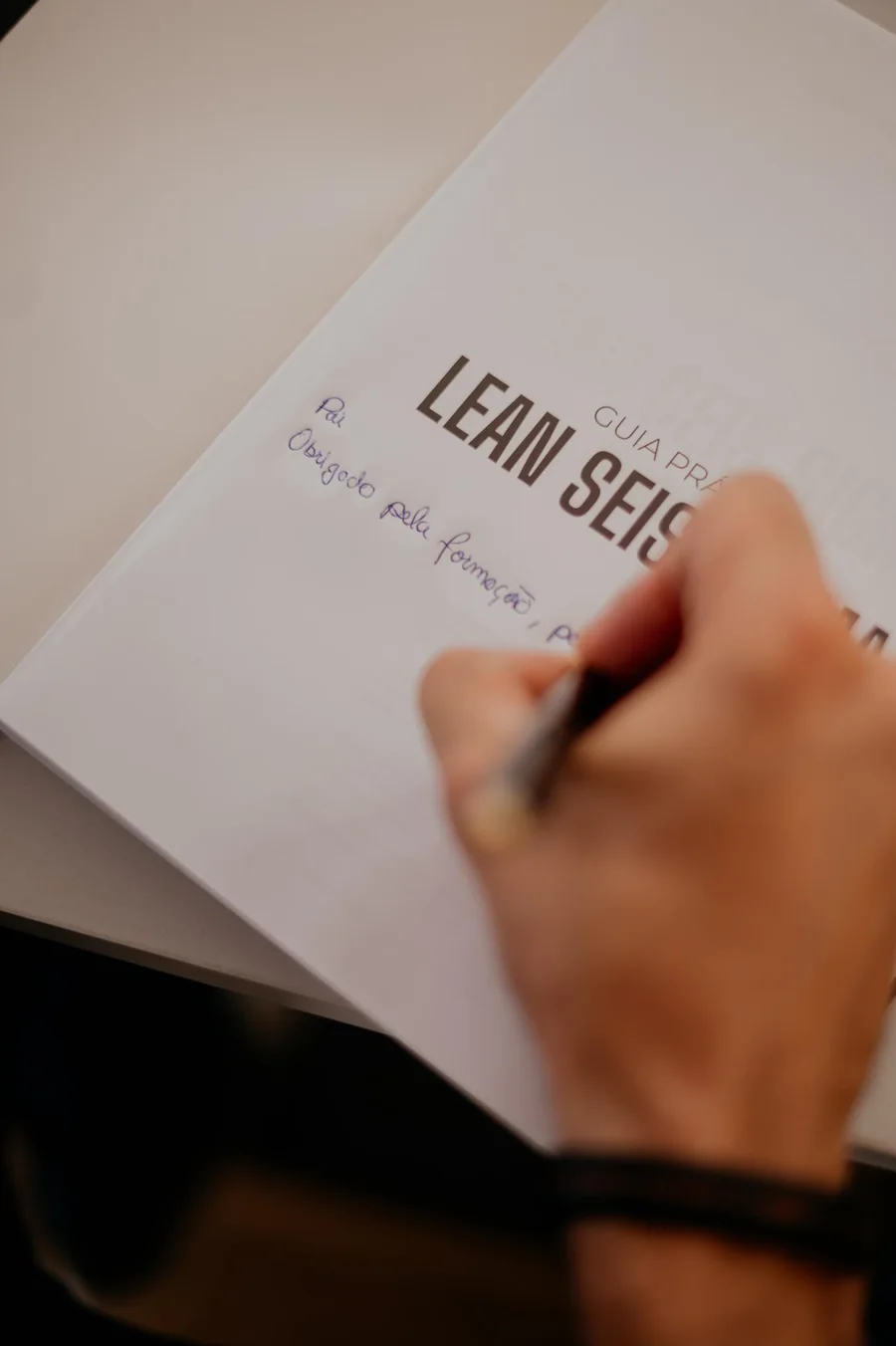 Mão escrevendo em um documento de projeto Lean Seis Sigma