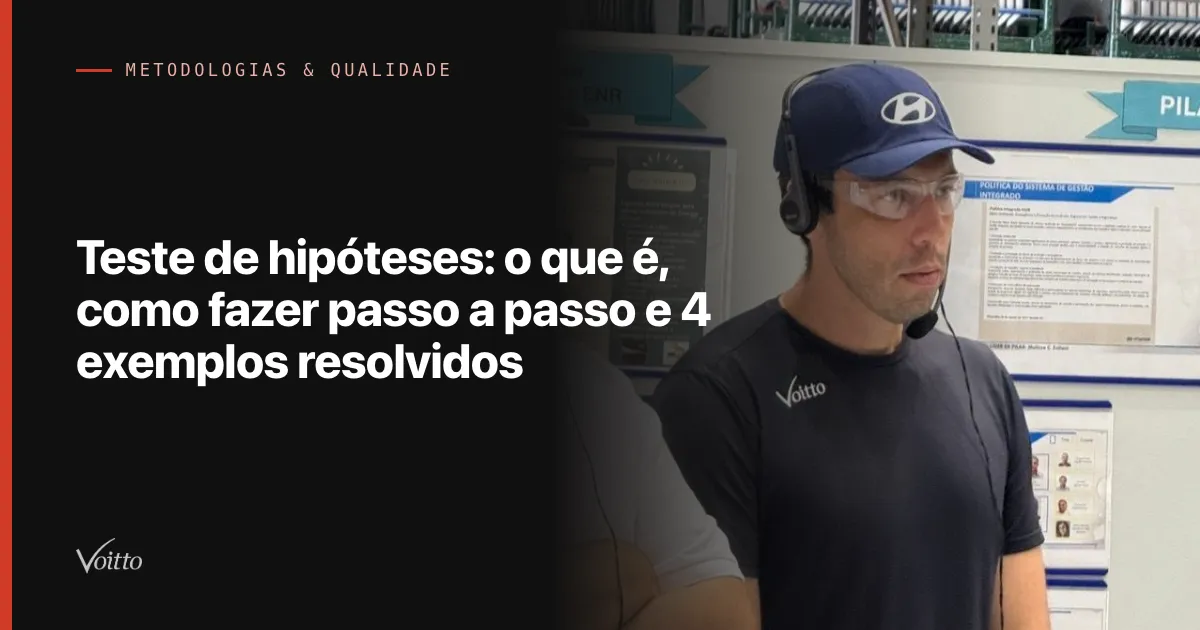 Homem de boné, óculos e camiseta preta da Voitto no chão de fábrica, com um painel de fotos ao fundo, com o texto Teste de hipóteses: o que é, como fazer passo a passo e 4 exemplos resolvidos