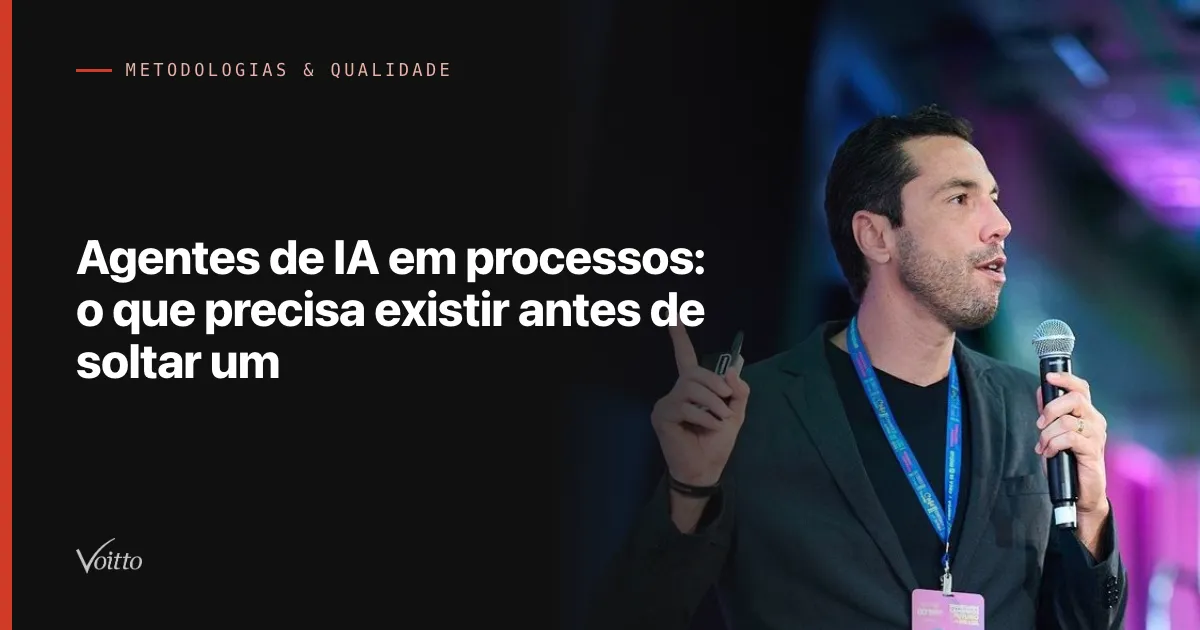 Homem de blazer cinza escuro e camiseta preta, com crachá em cordão azul, falando ao microfone de mão num palco de evento com luzes coloridas ao fundo e o dedo indicador da outra mão levantado, com o texto Agentes de IA em processos: o que precisa existir antes de soltar um sobre fundo escuro à esquerda