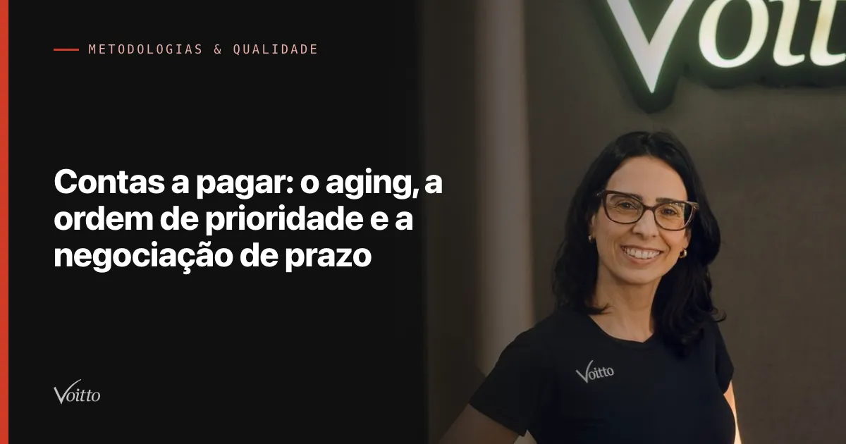 Colaboradora da Voitto de óculos e camiseta preta, sorrindo no escritório com o letreiro iluminado ao fundo, com o texto Contas a pagar: o aging, a ordem de prioridade e a negociação de prazo sobre fundo escuro à esquerda