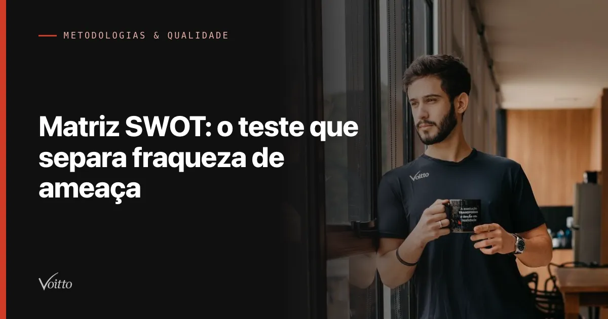 Colaborador da Voitto de camiseta preta segurando uma caneca, em pé no espaço de convivência do escritório, com o texto Matriz SWOT: o teste que separa fraqueza de ameaça sobre fundo escuro à esquerda