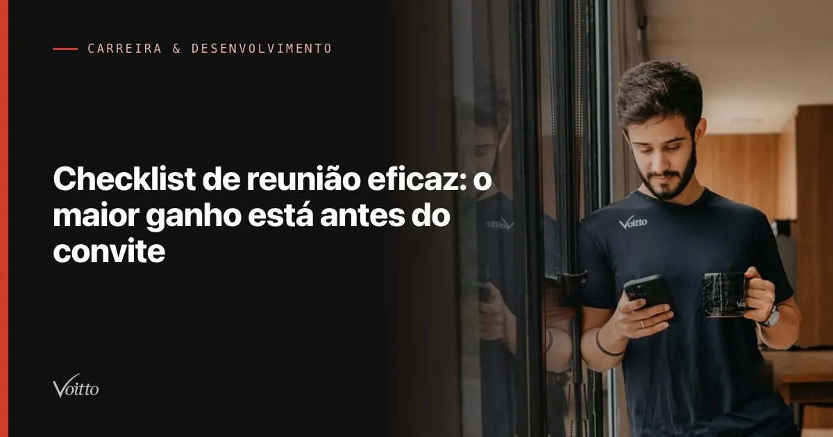 Colaborador da Voitto de camiseta preta olhando o celular em pé no escritório, junto à porta de vidro, com o texto Checklist de reunião eficaz: o maior ganho está antes do convite sobre fundo escuro à esquerda