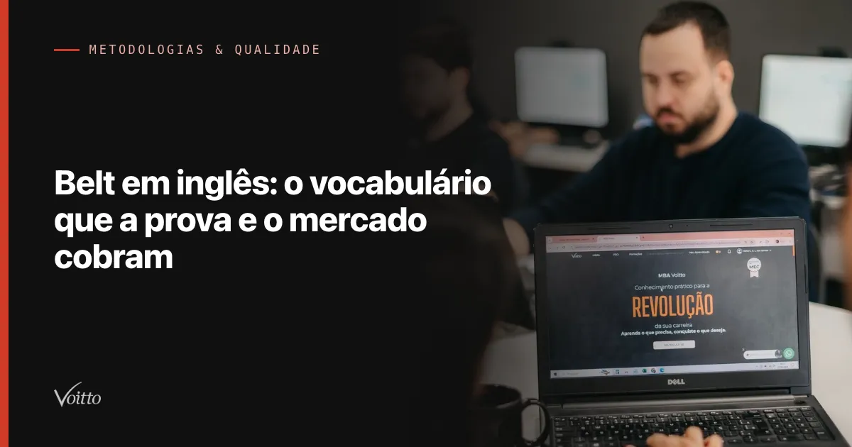 Colaborador da Voitto de barba e camisa escura, concentrado diante de um notebook aberto no escritório, com o texto Belt em inglês: o vocabulário que a prova e o mercado cobram sobre fundo escuro à esquerda