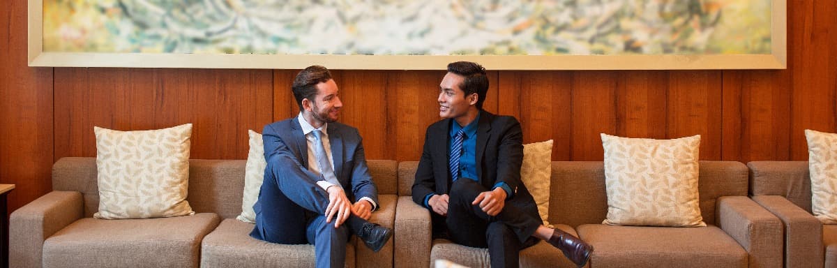 Dois executivos conversando em um lounge.