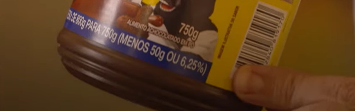 Rótulo indicando redução de 50g em embalagem de achocolatado em pó. Rótulo indicando redução de 50g em embalagem de achocolatado em pó.